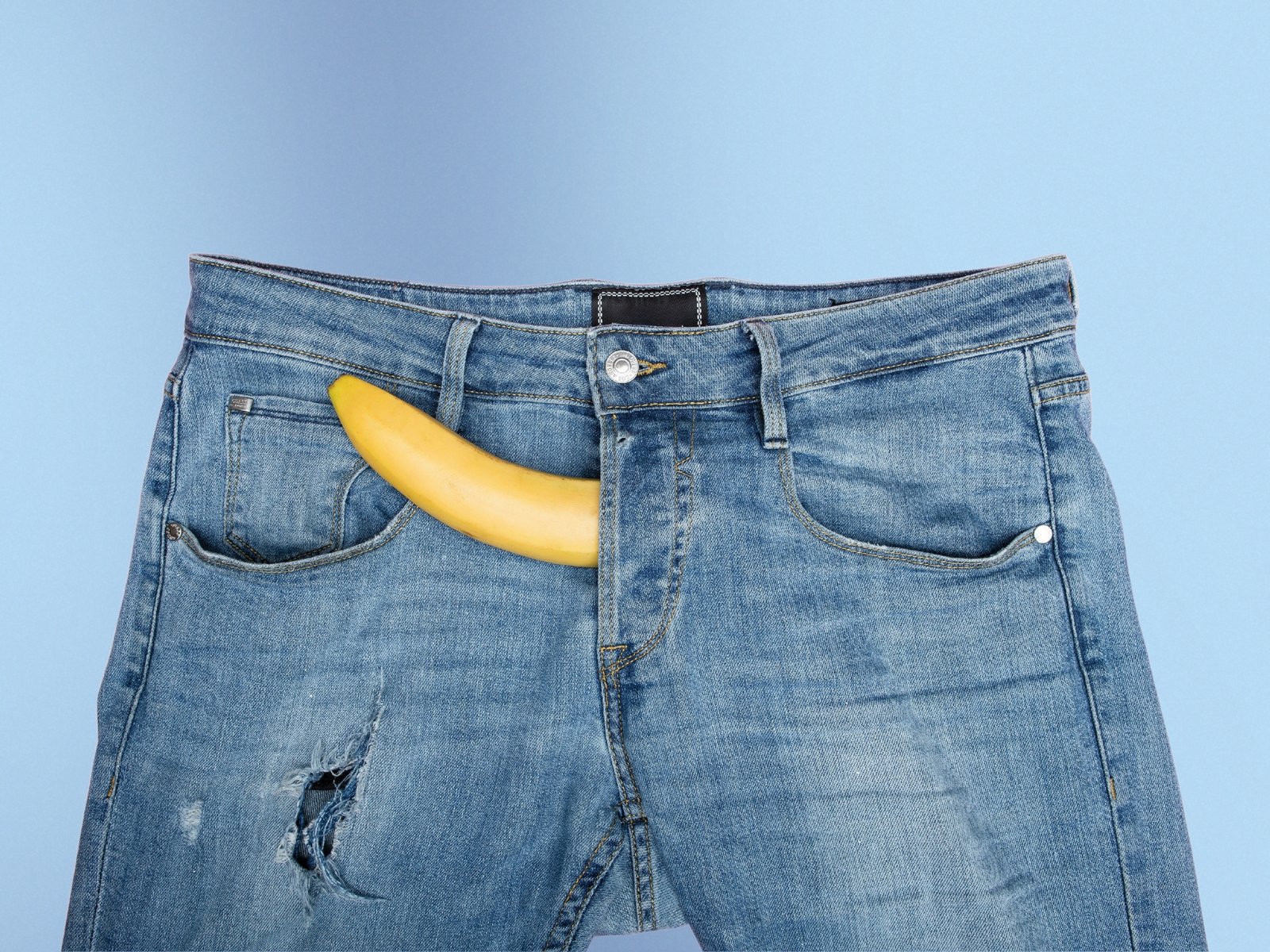 Pantaloni albaștri cu o banană simbolizând un penis